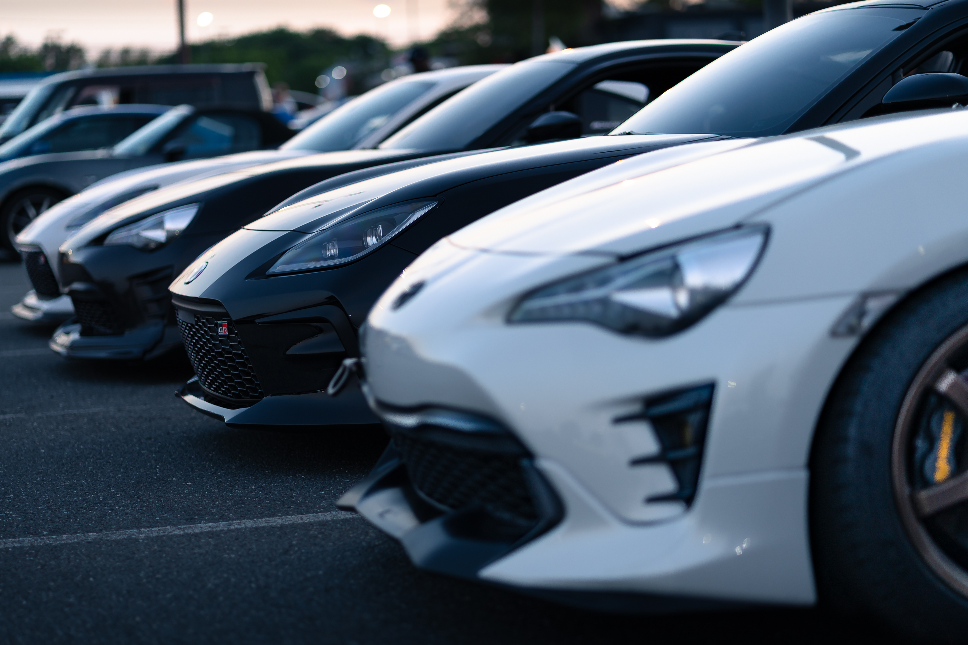 A lineup of modern sports cars parked at dusk